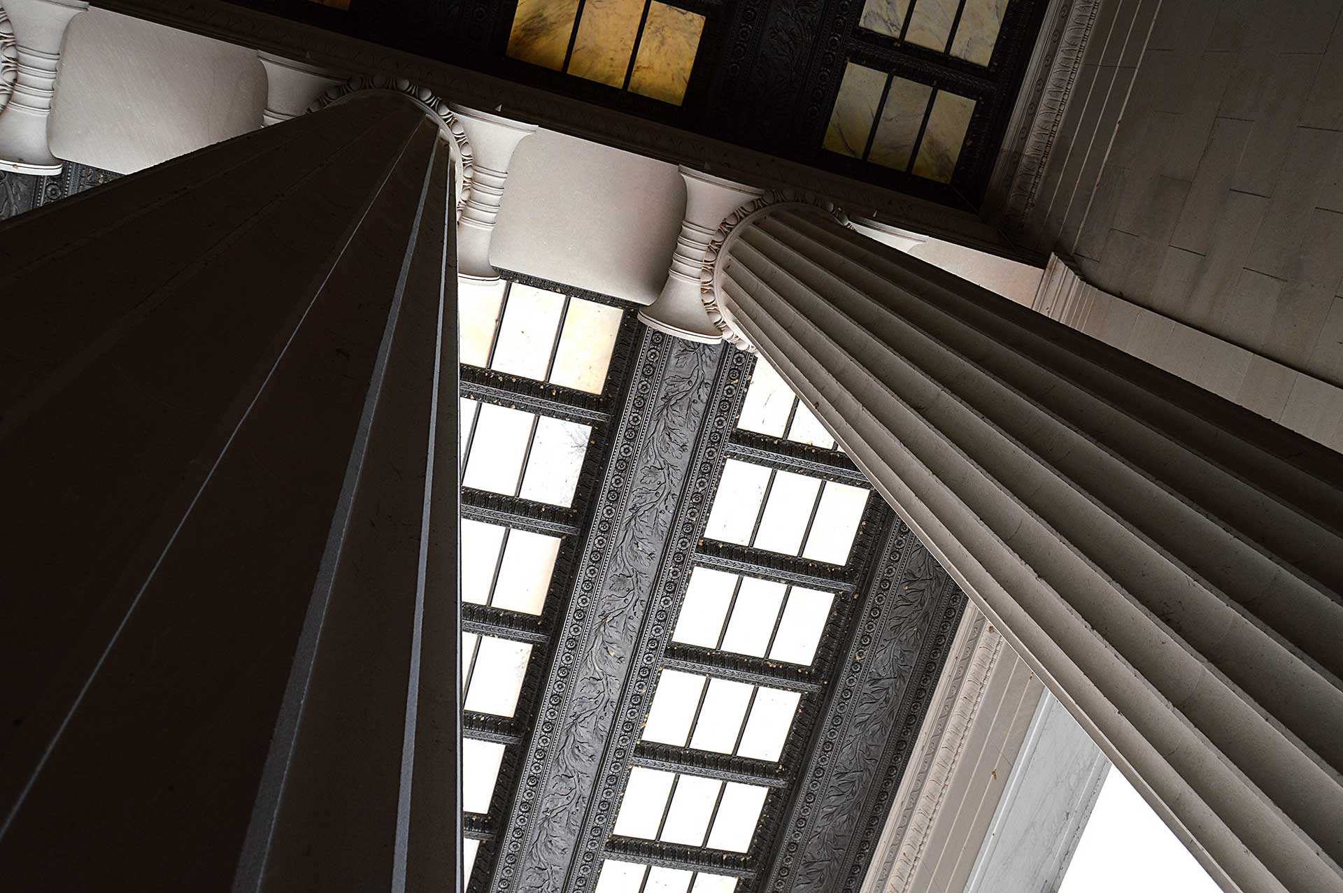 looking up towards ceiling at tall stone pillars